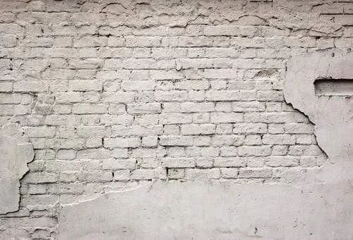 Белая штукатурка на кирпичной стене