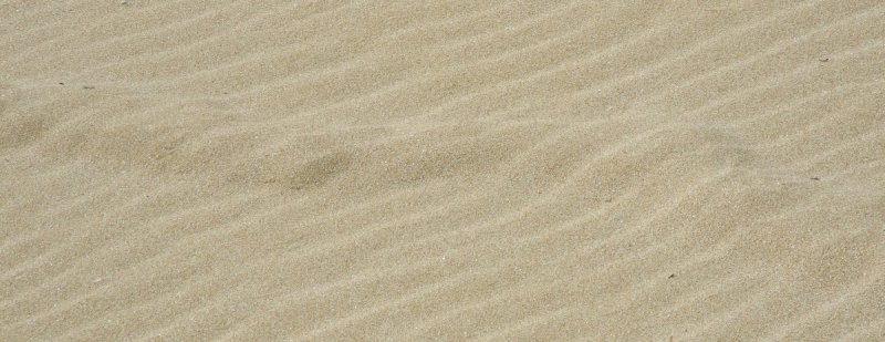 Синяя ткань на песке