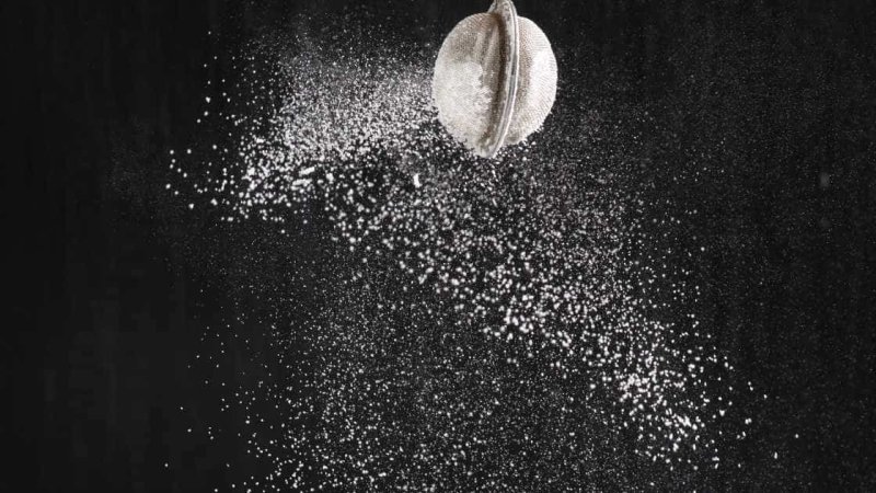 Рассыпанная мука на черном фоне